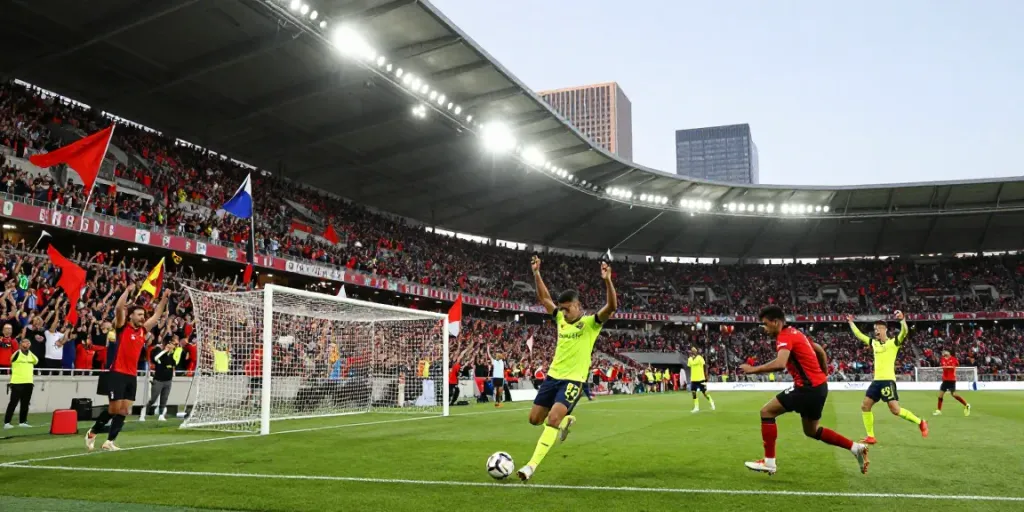 Young player celebrating at a packed football stadium with fans, showcasing the energy of TOP10 สโมสร.
